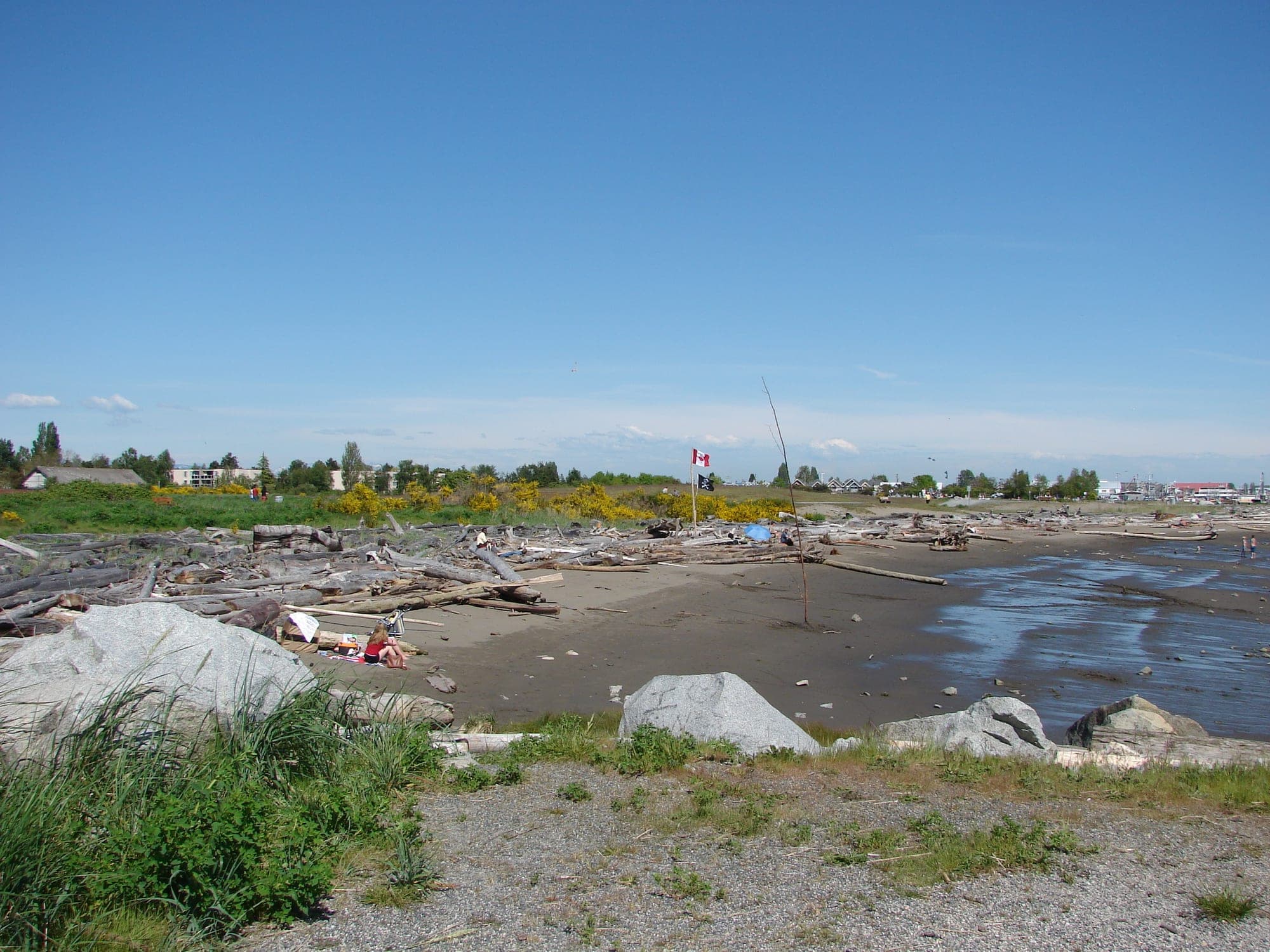 The sandy beach and driftwood-strewn shoreline at Garry Point Park in Richmond, looking west across the Strait of Georgia.