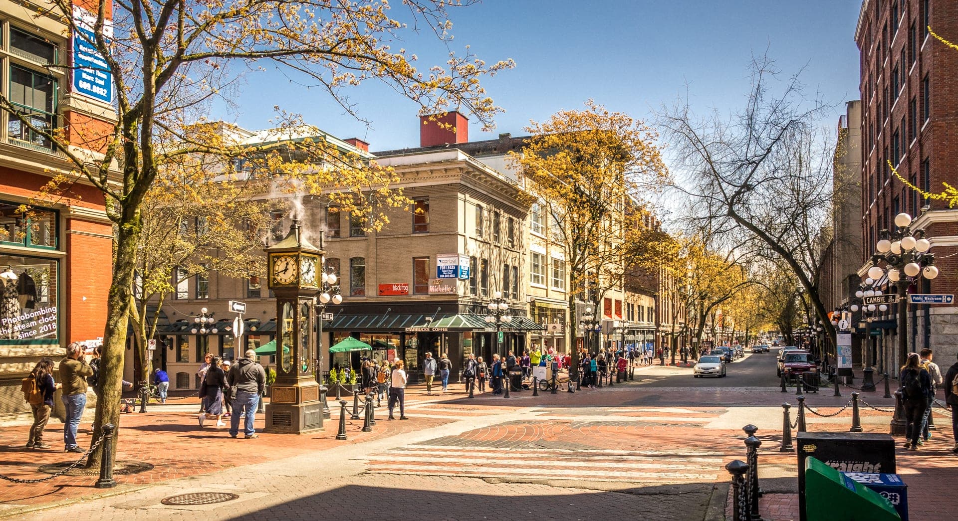 Gastown street scene in Vancouver showing brick heritage buildings along Water Street and cast-iron streetlamps.