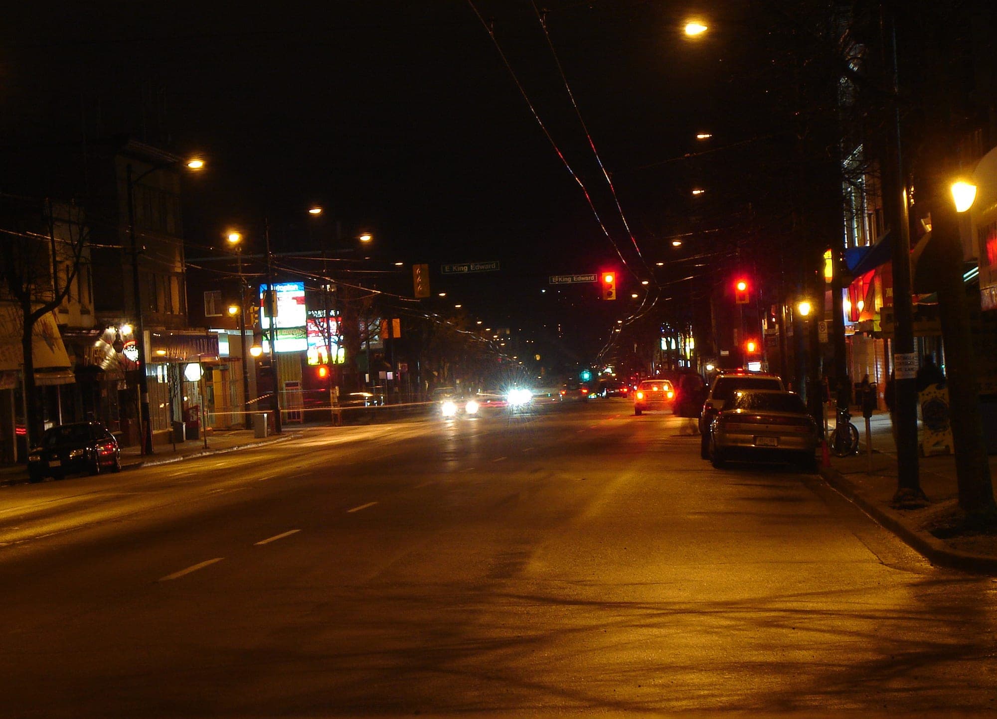 Night view of Main Street in Vancouver with shop lights and independent storefronts.