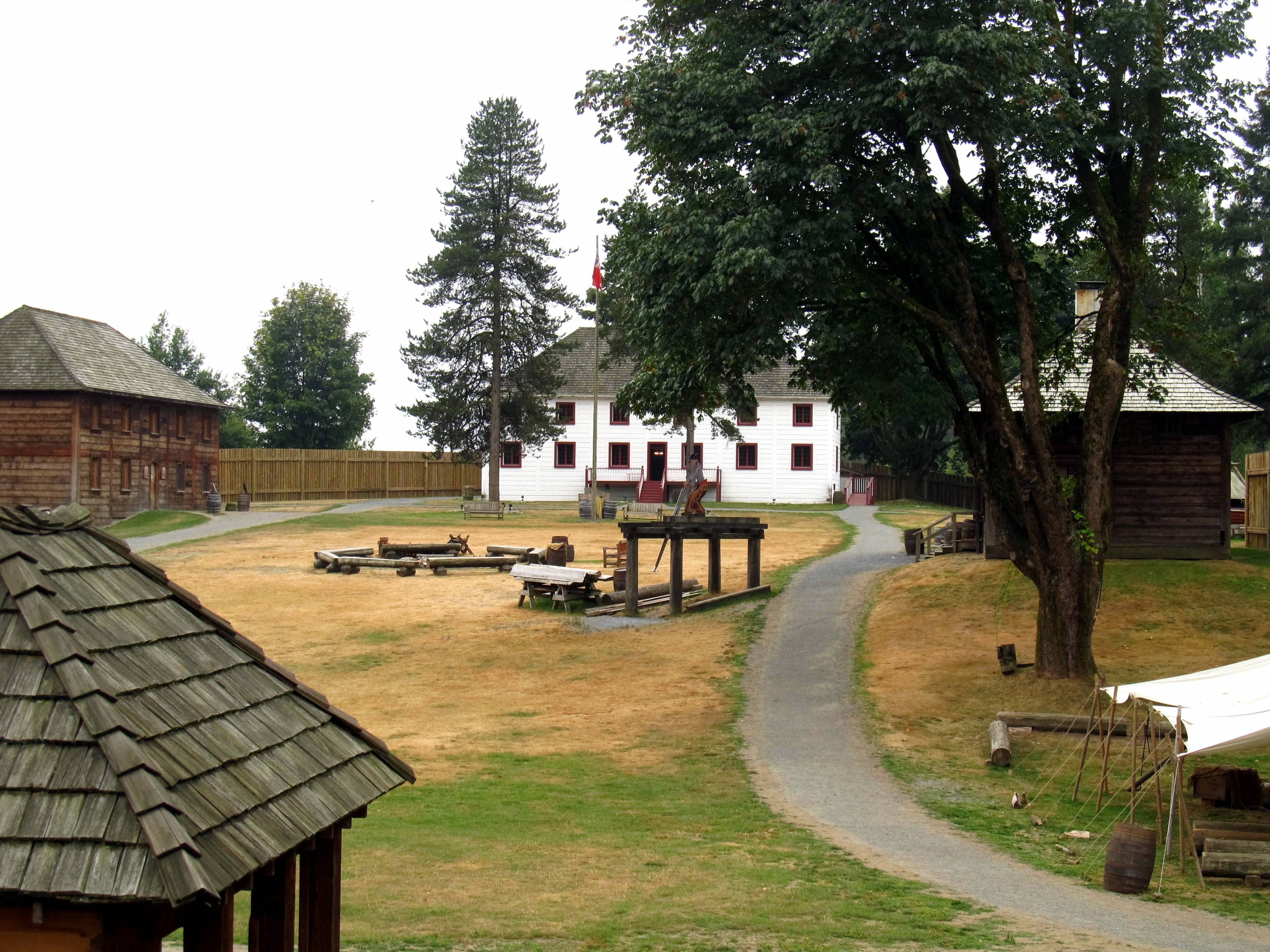 Fort Langley National Historic Site grounds looking south from the palisade gallery, with wooden trading-post buildings and grassy grounds — the historic heart of Langley, BC.